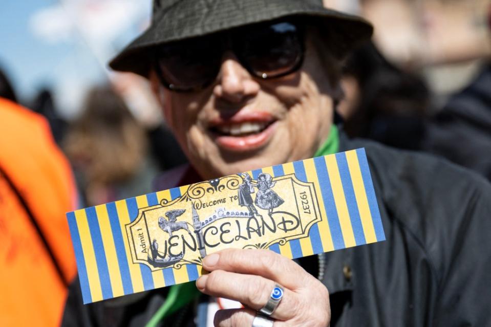 A protestor holds a fake ticket reading “Welcome to Veniceland” at an anti-access charge demonstration on the city’s Piazzale Roma on Apr. 25. AFP via Getty Images