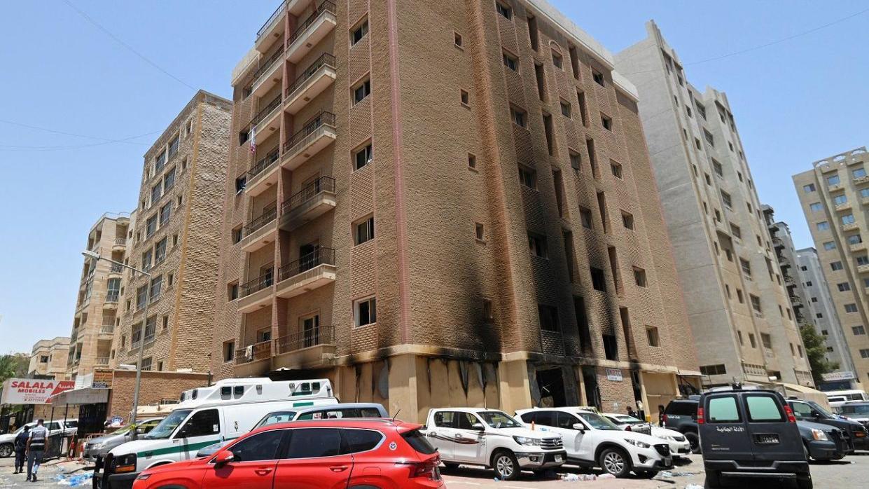 Vehicles are parked next to a building damaged following a deadly fire, in Mangaf, southern Kuwait, June 12, 2024