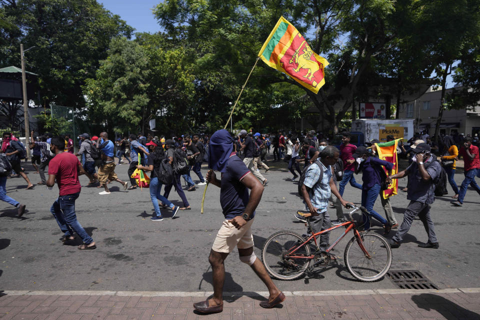 Protesters, some carrying national flags, storm the compound of Sri Lankan Prime Minister Ranil Wickremesinghe's office, demanding he resign after president Gotabaya Rajapaksa fled the country amid economic crisis in Colombo, Sri Lanka, Wednesday, July 13, 2022. Sri Lanka’s president fled the country without stepping down Wednesday, plunging a country already reeling from economic chaos into more political turmoil. Protesters demanding a change in leadership then trained their ire on the prime minister and stormed his office. (AP Photo/Eranga Jayawardena)