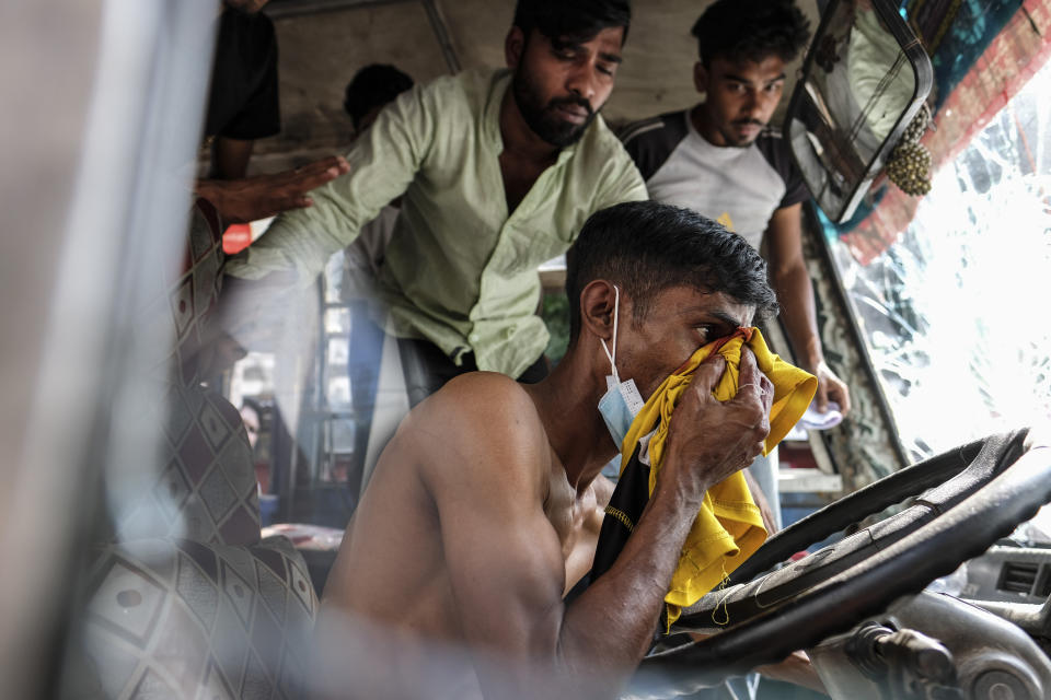 A bus driver gets injured as Bangladeshi garment workers vandalize buses during a protest demanding an increase in their wages at Mirpur in Dhaka, Bangladesh, Tuesday, Oct.31, 2023. (AP Photo/Mahmud Hossain Opu)