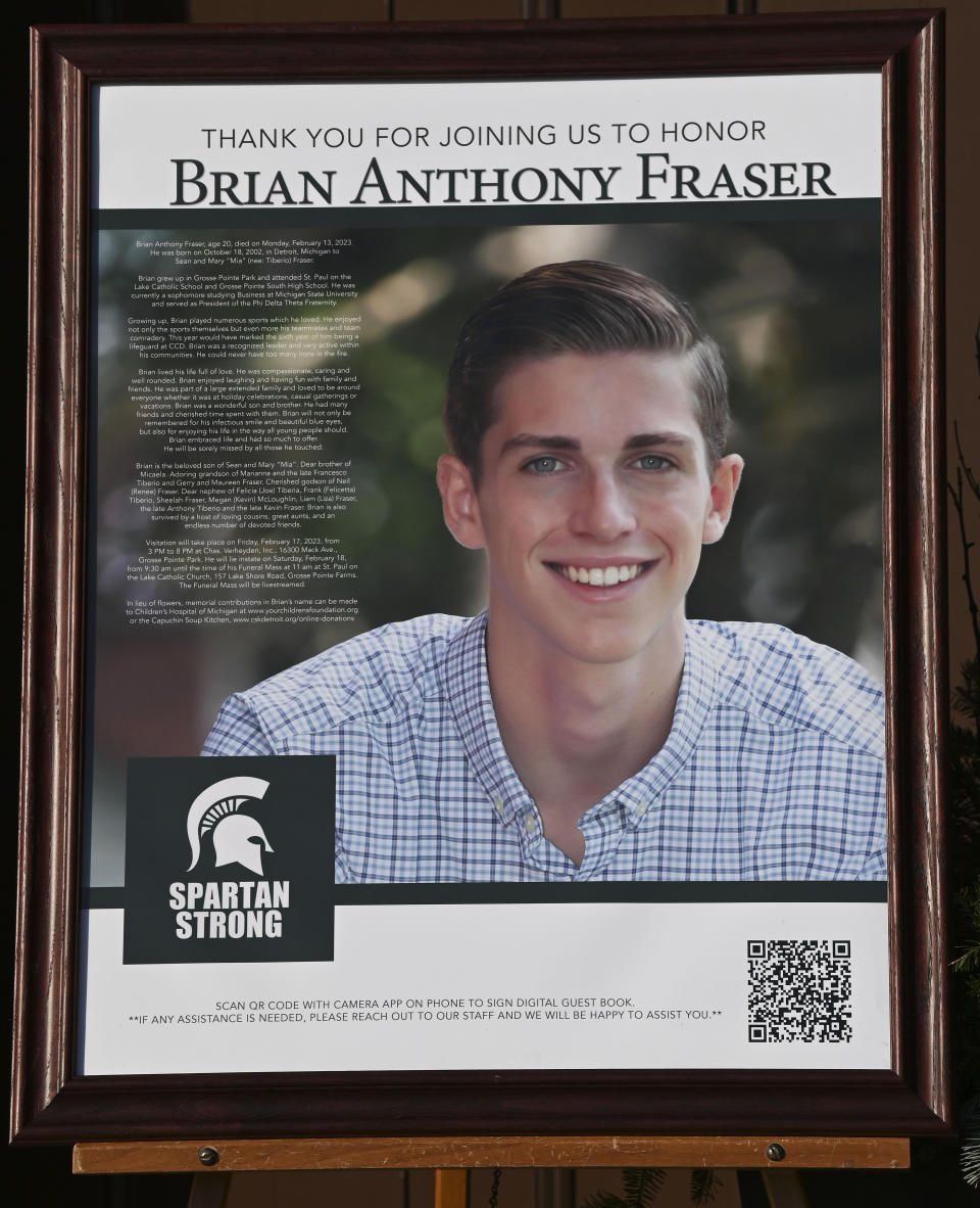 A poster of Brian Anthony Fraser is displayed outside the church as family members friends and supporters console each other during the funeral mass for Brian Fraser at St Paul on the Lake Catholic Church, in Grosse Pointe Farms, Mich., Saturday, Feb. 18, 2023. Fraser was identified as one of three students slain during a mass shooting on Michigan State University's campus, Monday evening. (Todd McInturf/Detroit News via AP, Pool)
