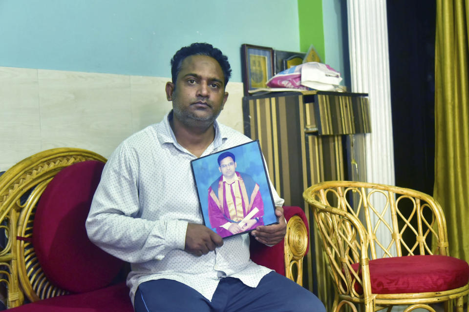 A relative holds a photograph of Dr. Jibraeil, assistant professor of history at Aligarh Muslim Uliversity, who died of COVID-19, in Aligarh, India, Saturday, June 12, 2021. Within just one month, the official Facebook page of Aligarh Muslim University, one of the topmost in India, published about two dozen obituaries of its teachers, all lost to the pandemic. Across the country, the deaths of educators during the devastating surge in April and May have left students and staff members grief-stricken and close-knit university communities shaken.(AP Photo/Manoj Aligadi)