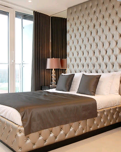 <b>Over-size your headboard</b><br><br>The bed should always take centre stage in a bedroom and a plush, padded headboard is a short cut to luxury. The huge designer headboard shown, £2,594 from <a href="http://www.juliettesinteriors.co.uk/bedroom-furniture/headboards/luxurious-designer-headboard.html" rel="nofollow noopener" target="_blank" data-ylk="slk:Juliette Interiors;elm:context_link;itc:0;sec:content-canvas" class="link ">Juliette Interiors </a>comes without or without Swarovski crystal buttons. It that’s beyond your means (if not, lucky you!), get the look with 3D-effect wallpaper from <a href="http://www.rockettstgeorge.co.uk/padded-linen-beige-wallpaper---koziel-10m-roll-11479-p.asp" rel="nofollow noopener" target="_blank" data-ylk="slk:Rockett St George;elm:context_link;itc:0;sec:content-canvas" class="link ">Rockett St George</a>. <br>