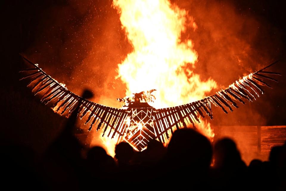 Revellers cheer as a wooden phoenix is burned (Reuters)