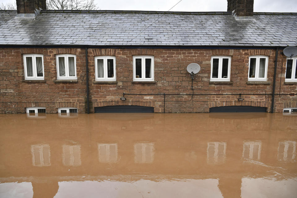 A row of flooded cottages in Monmouth, Wales, Tuesday Feb. 18, 2020. Britain's Environment Agency issued severe flood warnings Monday, advising of life-threatening danger after Storm Dennis dumped weeks' worth of rain in some places. (Ben Birchall/PA via AP)