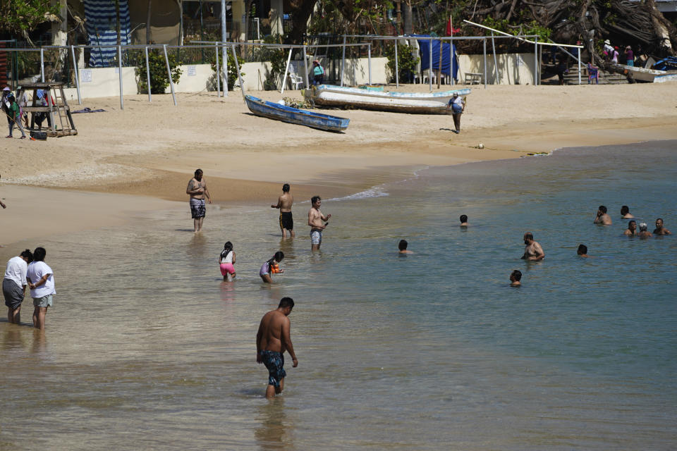 Residents enjoy the beach in Acapulco, Mexico, Sunday, Nov. 12, 2023. Nearly three weeks after the Category 5 hurricane devastated this Pacific port, leaving at least 48 people dead and the city's infrastructure in tatters, the cleanup continues. (AP Photo/Marco Ugarte)