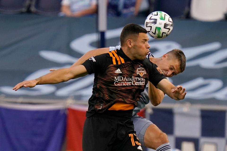 Houston Dynamo forward Christian Ramirez, left,  heads the ball against Sporting Kansas City defender Matt Besler, right, during the first half of an MLS soccer match in Kansas City, Kan., Tuesday, Aug. 25, 2020. (AP Photo/Orlin Wagner)