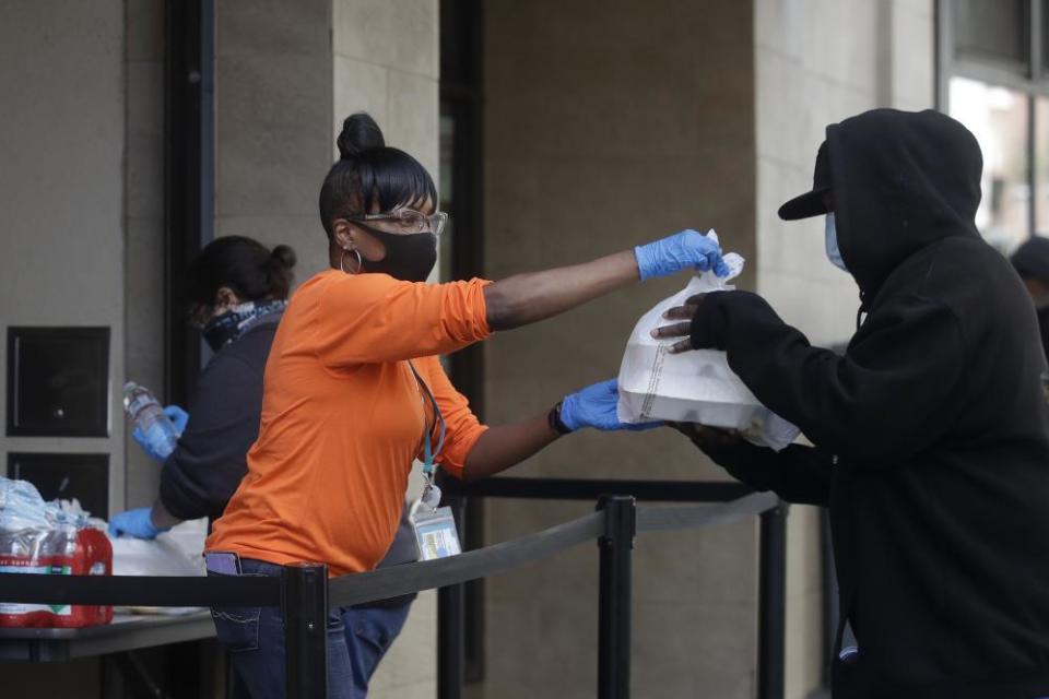 Felicia Senigar, left, hands out food in San Francisco in April.