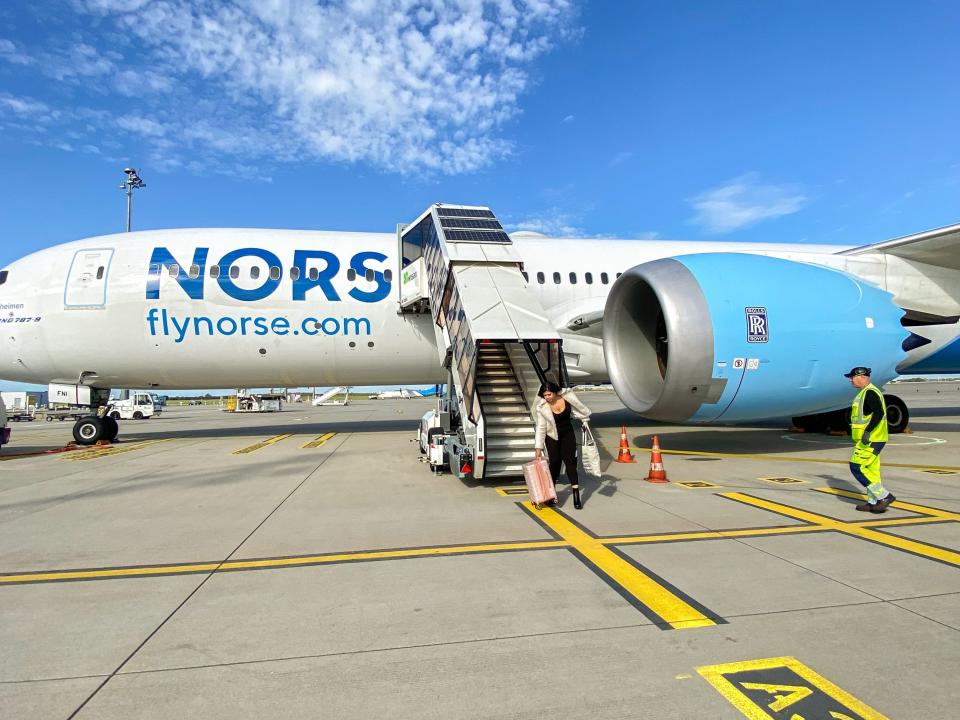 A Norse aircraft on the ground with blue skies and clouds in the background.