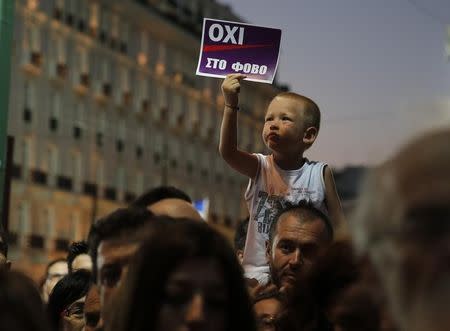 A child holds up a sign reading "No to Fear" in Greek during an anti-austerity demonstration in Syntagma Square in Athens, July 3, 2015. REUTERS/Yannis Behrakis