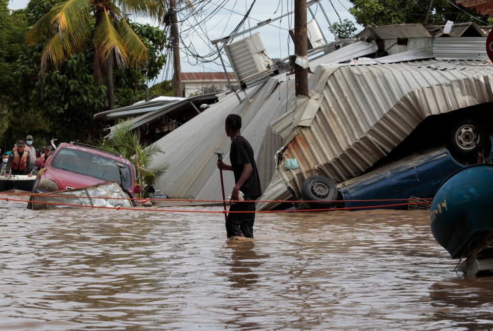 In this Nov. 6, 2020, file photo, a resident walking through a flooded street looks back at storm damage caused by Hurricane Eta in Planeta, HondurasCopyright 2020 The Associated Press. All rights reserved