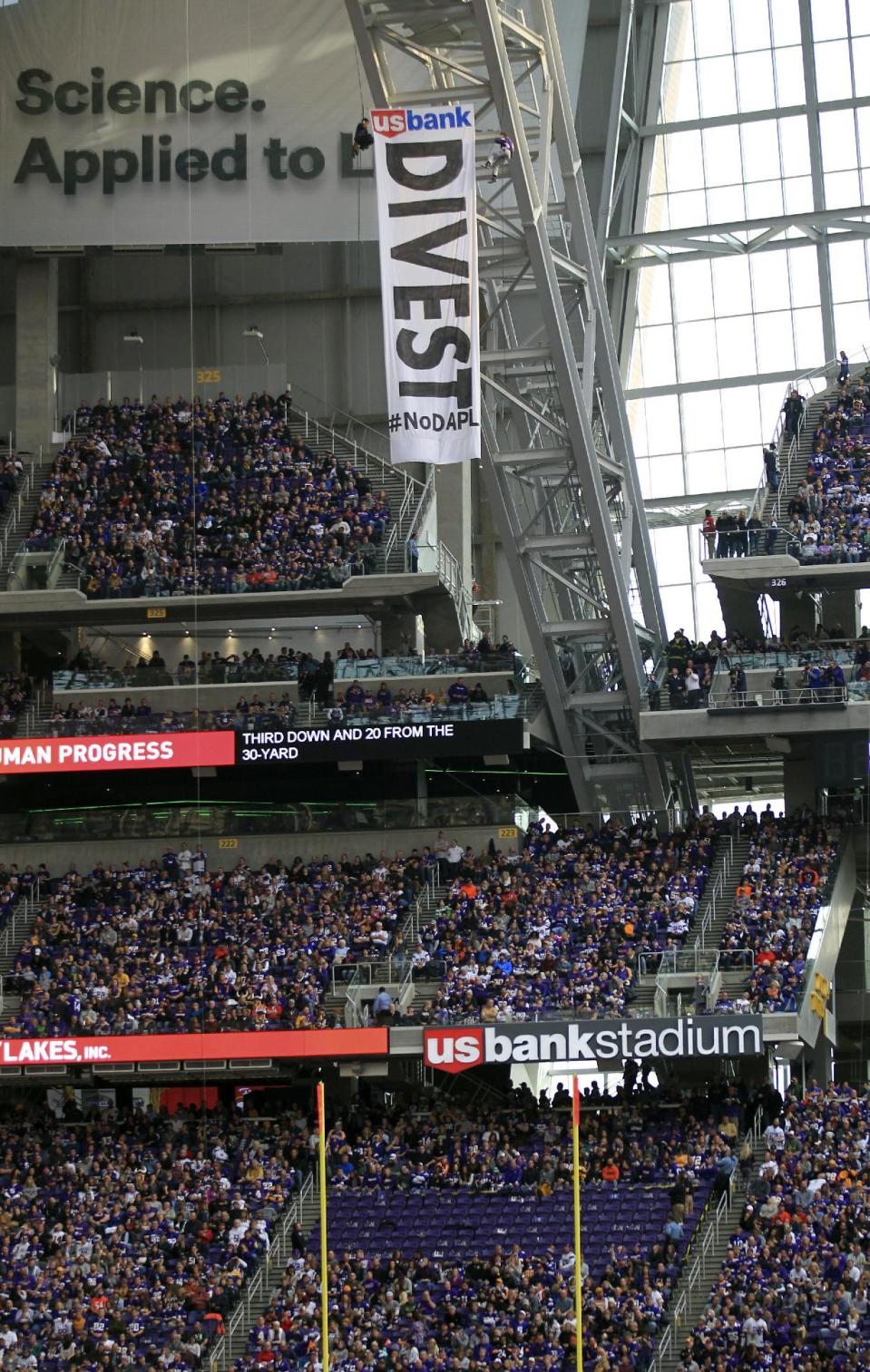 Protesters against the Dakota Access Pipeline rappel from the catwalk in U.S. Bank Stadium during the first half of an NFL football game between the Minnesota Vikings and the Chicago Bears, Sunday, Jan. 1, 2017, in Minneapolis. (AP Photo/Andy Clayton-King)