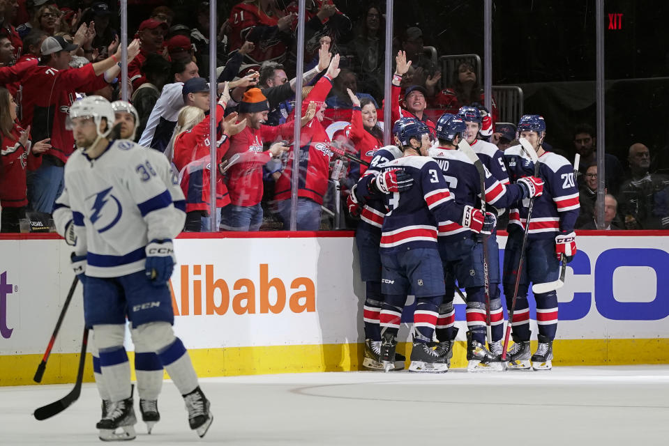 Members of the Washington Capitals celebrate Aliaksei Protas' goal in the second period of an NHL hockey game against the Tampa Bay Lightning, Friday, Nov. 11, 2022, in Washington. (AP Photo/Patrick Semansky)