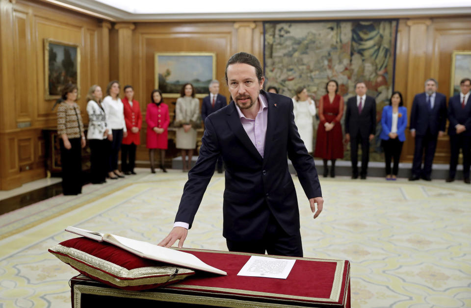 Podemos (United We Can) leader Pablo Iglesias takes his oath of office during the swearing in ceremony at the Zarzuela Palace just outside of Madrid, Spain, Monday Jan. 13, 2020. Iglesias will be the deputy prime minister in charge of social rights and sustainable development in. in Spain's center to far left-wing coalition administration. (Emilio Naranjo/ Pool Photo via AP)