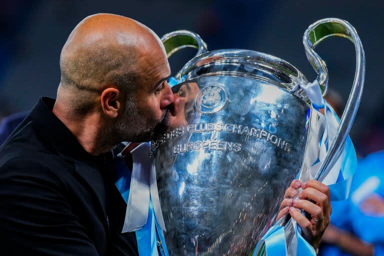 El DT español 'Pep' Guardiola besa el trofeo tras ganar la Champions anterior con Manchester City