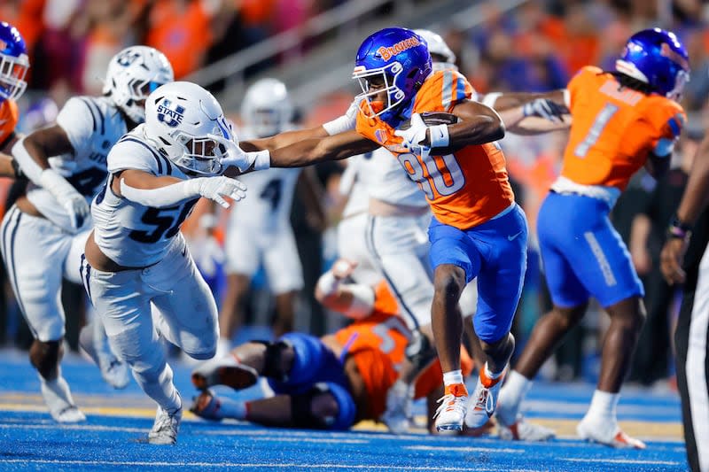 Boise State wide receiver Cameron Bates (80) stiff arms a Utah State defender on a run in the second half of an NCAA college football game, Saturday, Oct. 5, 2024, in Boise, Idaho. Boise State won 62-30. (AP Photo/Steve Conner) | Steve Conner