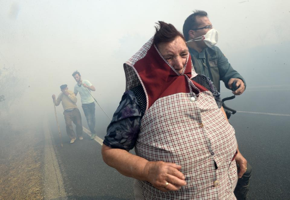 A Spanish Civil Guard officer helps villagers during a <a href="http://www.theguardian.com/world/gallery/2015/aug/31/wildfires-spain-in-pictures">fire in Cabreiro</a>, Spain,&nbsp;on Aug. 30.