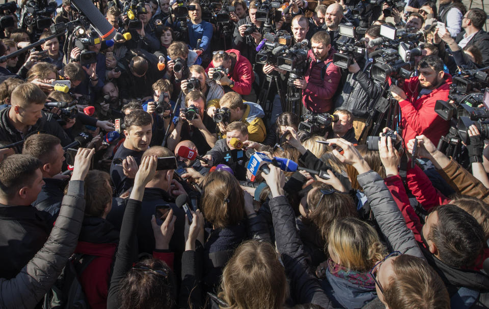 Ukrainian comedian and presidential candidate Volodymyr Zelenskiy, left, is surrounded by journalists after voting at a polling station, during the presidential elections in Kiev, Ukraine, Sunday, March. 31, 2019. (AP Photo/Emilio Morenatti)