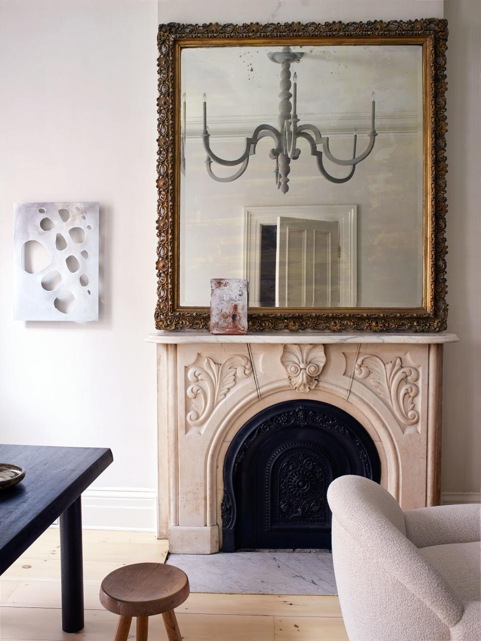 Tedhams used raw Marmorino plaster (finished with beeswax to add a subtle sheen) on the walls of the home’s parlor level. The fireplace, mantel, and mirror, which are original to the house, were paired with a slim custom-designed wooden chandelier and an abstract metal panel made by the designer, who holds a Master of Fine Arts from the University of Illinois at Chicago.