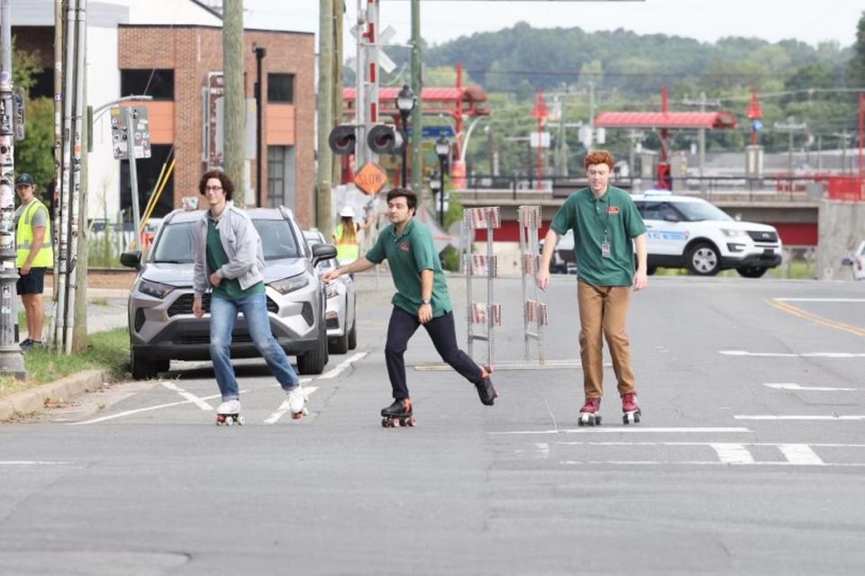 John Higgins, center, and Ben Marshall, right, of “Saturday Night Live”, along with a stunt double representing Martin Herlihy at left, film scenes from “Please Don’t Destroy” in NoDa on July 25.
