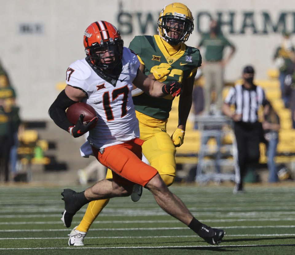 Oklahoma State wide receiver Dillon Stoner, left, scores past Baylor safety JT Woods, right, in the first half of an NCAA college football game, Saturday, Dec. 12, 2020, in Waco, Texas. (Rod Aydelotte/Waco Tribune-Herald via AP)