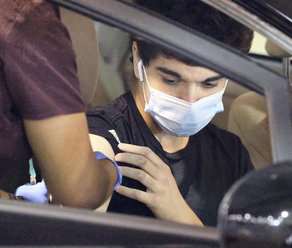 A 16-year-old Orange County resident gets a COVID-19 vaccine at the Florida Department of Health drive-thru site at the Orange County Convention in Orlando, Fla., Monday, April 5, 2021. Beginning Monday, all residents 16 or older are eligible to receive the vaccine, per an executive order issued by Florida Gov. Ron DeSantis. (Joe Burbank/Orlando Sentinel via AP)