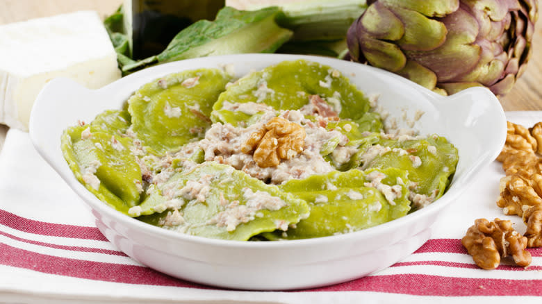 artichoke stuffed pasta in white serving dish