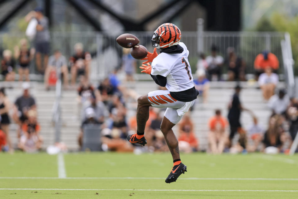 Cincinnati Bengals' Ja'Marr Chase attempts to catch two footballs as he participates in a drill during a practice at the NFL football team's training facility in Cincinnati, Monday, Aug. 1, 2022. (AP Photo/Aaron Doster)