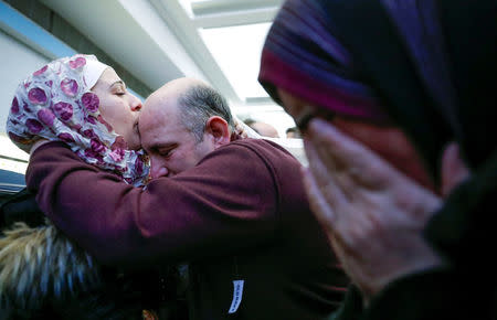 Syrian refugee Baraa Haj Khalaf (L) kisses her father Khaled as her mother Fattoum (R) cries after arriving at O'Hare International Airport in Chicago, Illinois, U.S. February 7, 2017. REUTERS/Kamil Krzaczynski/Files