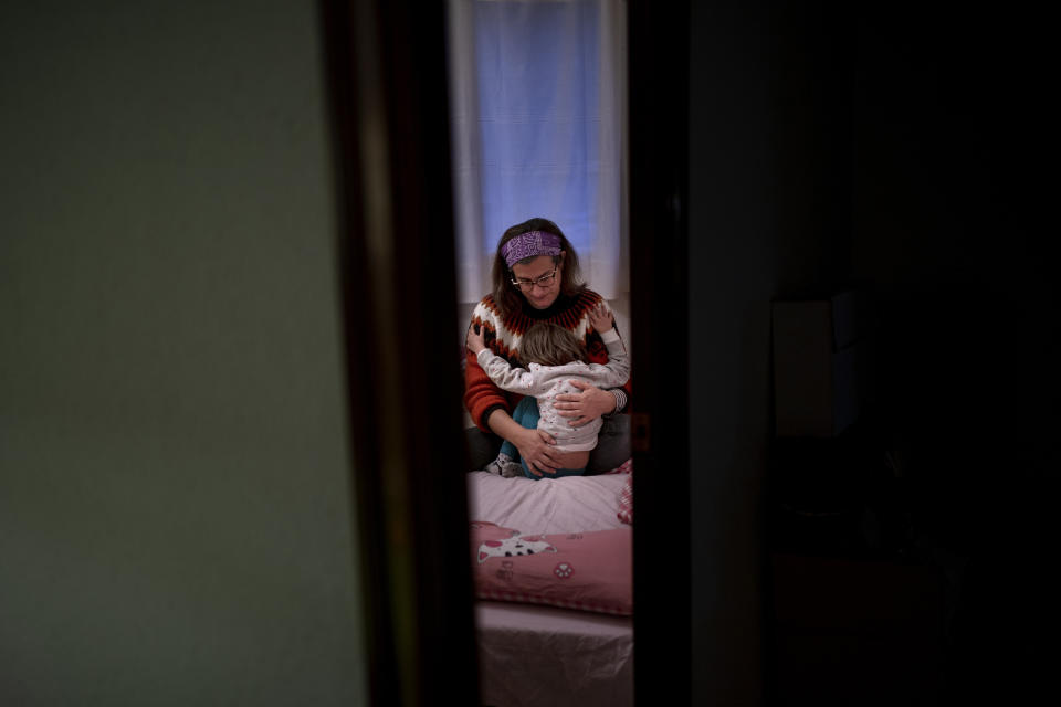 Victoria Martinez, 44, hugs her daughter as she wakes her up for school at their home in Barcelona, Spain, Monday, Feb. 8, 2021. By May this year, barring any surprises, Martinez will complete a change of both gender and identity at a civil registry in Barcelona, finally closing a patience-wearing chapter that has been stretched during the pandemic. The process, in her own words, has also been “humiliating.” (AP Photo/Emilio Morenatti)