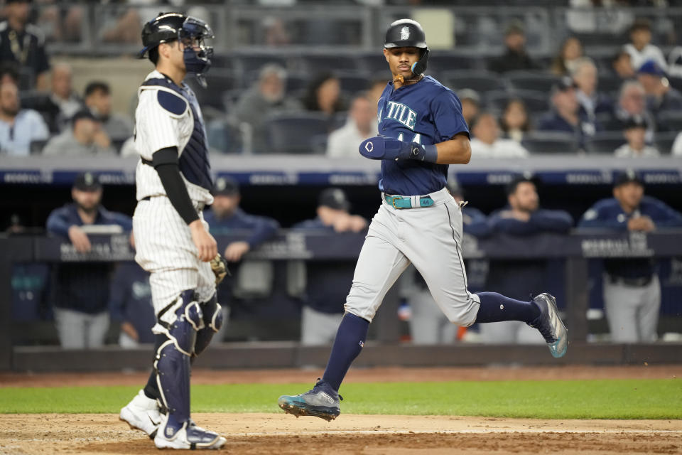 Seattle Mariners' Julio Rodriguez (44) runs home to score on an RBI sacrifice fly by Jarred Kelenic off New York Yankees relief pitcher Tommy Kahnle in the ninth inning of a baseball game, Wednesday, June 21, 2023, in New York. (AP Photo/John Minchillo)