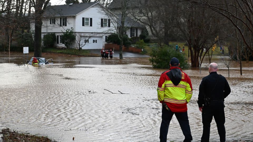  Firefighters rescue a man in car stuck in the flooded area in Charlotte, North Carolina, on Tuesday. - Peter Zay/Anadolu Agency/Getty Images