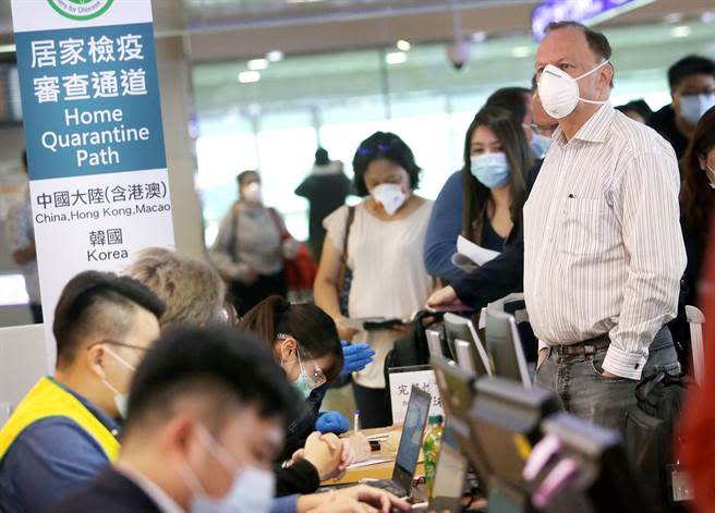 圖為1群外籍旅客正在排隊查驗健康聲明書。（資料照,范揚光攝）