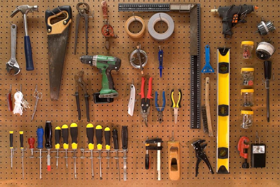 Collection of work tools in a workshop mounted on a peg board