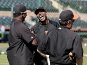 San Francisco Giants former player Barry Bonds, middle, talks with other coaches during batting practice before a spring training baseball game between the Giants and the Chicago Cubs in Scottsdale, Ariz., Monday, March 10, 2014. Bonds starts a seven day coaching stint today. (AP Photo/Chris Carlson)
