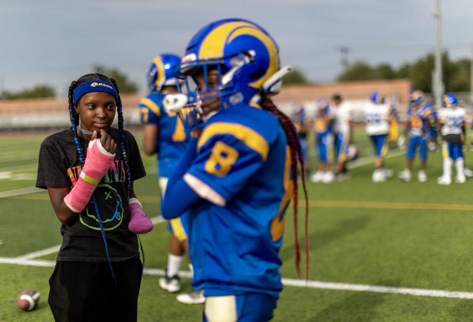 With both arms fitted with casts, La'Veyah Mosley, 12, left, watches her twin sister La'Viyah