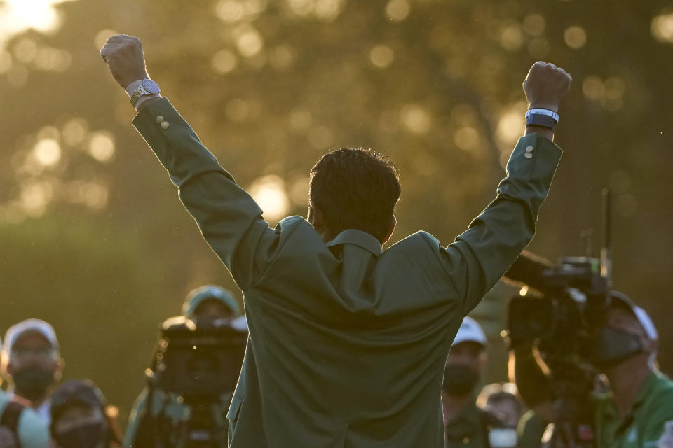 Hideki Matsuyama, of Japan, puts on the champion's green jacket after winning the Masters golf tournament on Sunday, April 11, 2021, in Augusta, Ga. (AP Photo/Charlie Riedel)