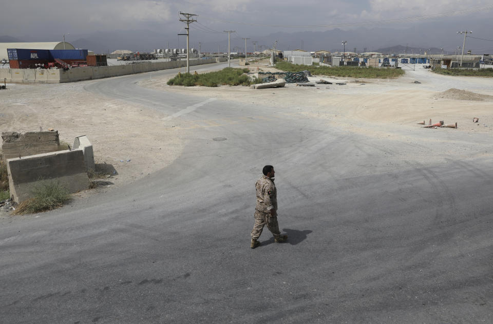 A member of the Afghan security forces walks in the sprawling Bagram air base after the American military departed, in Parwan province north of Kabul, Afghanistan, Monday, July 5, 2021. The U.S. left Afghanistan's Bagram Airfield after nearly 20 years, winding up its "forever war," in the night, without notifying the new Afghan commander until more than two hours after they slipped away. (AP Photo/Rahmat Gul)