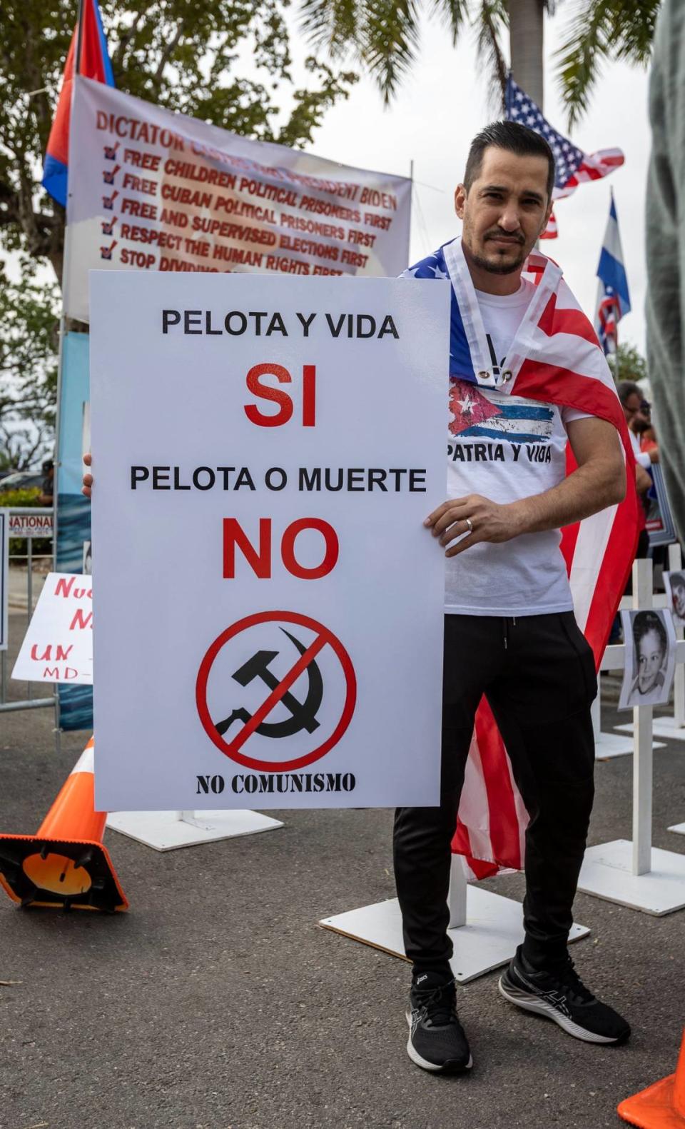 MIAMI, FL- March 19, 2023 - A protestor shows off his sign in front of loanDepot Park prior to the baseball game between Cuba and the United States.