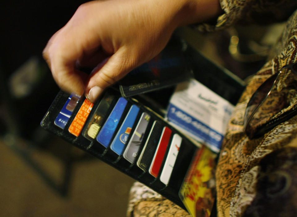 KENDALL, FL - MARCH 07:  Ileana Garcia looks in her wallet for credit cards she wants to melt over a hot plate as she tries to dig herself out of credit card debt during a sermon by Kevin Cross about faith-based financial management at the Miami Vineyard Community Church on March 7, 2009 in Kendall, Florida. Cross preaches to people about the biblical principles of money management with his idea of steps that should be taken for handling finances to glorify and honor God. With the economic hard times that have fallen upon many people, churches around the country are trying new programs such as Cross's Margin and Meaning events, to guide people out of their debt and get back on their feet financially.  (Photo by Joe Raedle/Getty Images)