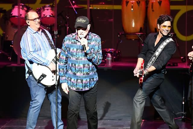 <p>Scott Dudelson/Getty</p> Jeff Foskett, Mike Love and John Stamos perform in California in March 2018