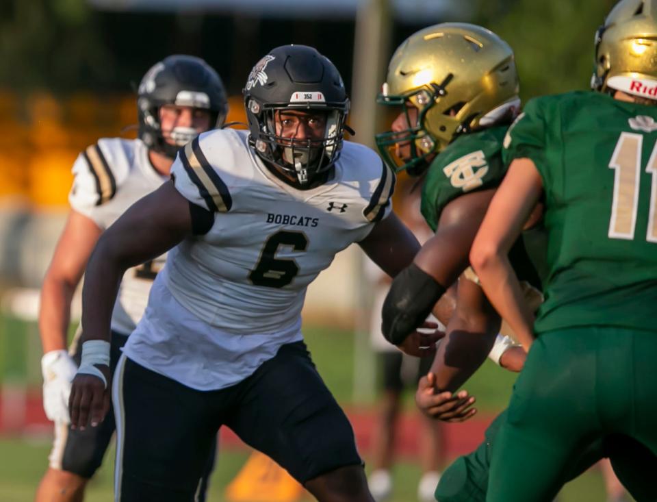 Buchholz High School Gavin Hill (6) goes after Trinity Catholic quarterback Alan Means (11) as Buchholz travels to Trinity Catholic high school for a preseason game in Ocala, Florida on Friday August 19, 2022.  [Alan Youngblood/Special to the Ocala Star-Banner]