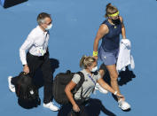 Karolina Muchova, right, of the Czech Republic was from the court for medical treatment during her quarterfinal against Australia's Ash Barty at the Australian Open tennis championship in Melbourne, Australia, Wednesday, Feb. 17, 2021.(AP Photo/Hamish Blair)