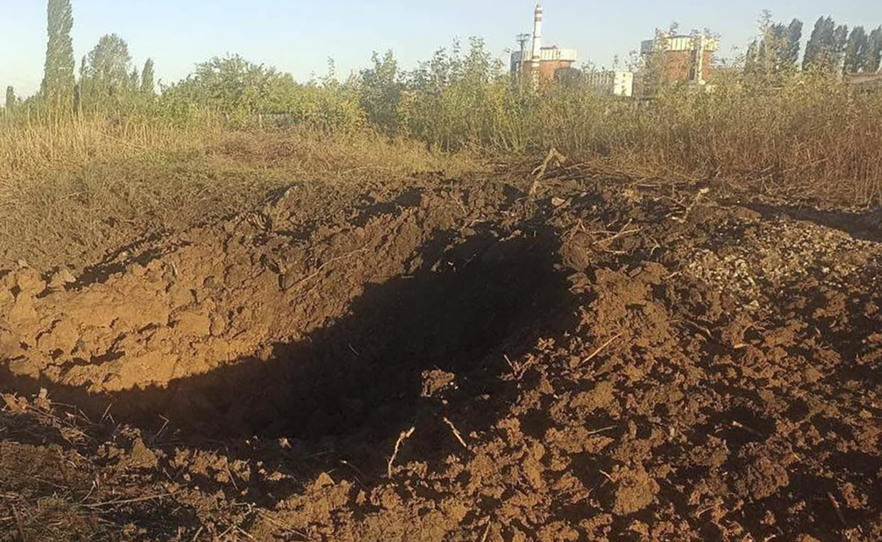 In this photo A crater left by a Russian rocket is seen 300 meter from the South Ukraine nuclear power plant, in the background, close to Yuzhnoukrainsk, Mykolayiv region, Ukraine, Monday, Sept. 19, 2022. (South Ukraine Nuclear Power Plant Press Office via AP) by the South Ukraine nuclear power plant, a crater left by a Russian rocket is seen 300 meter from the South Ukraine nuclear power plant, in the background, close to Yuzhnoukrainsk, Mykolayiv region, Ukraine, Monday, Sept. 19, 2022. (South Ukraine Nuclear Power Plant Press Office via AP)