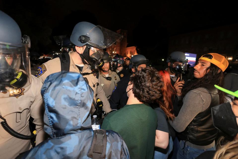 Pro-Palestinian protesters face off with officers near an encampment at UCLA in the US (REUTERS)