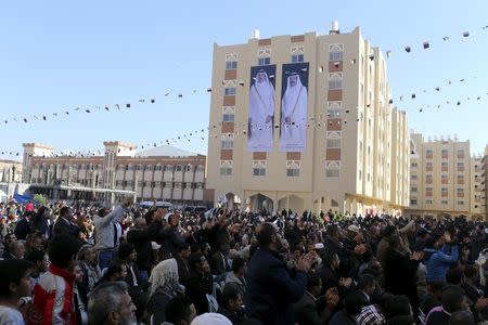 Posters depicting Qatar's former Emir Sheikh Hamad bin Khalifa al-Thani (R) and Emir of Qatar Tamim bin Hamad al-Thani are seen on a building as people attend the opening ceremony of Qatari-funded construction project "Hamad City", in Khan Younis in the southern Gaza Strip January 16, 2016. REUTERS/Ibraheem Abu Mustafa