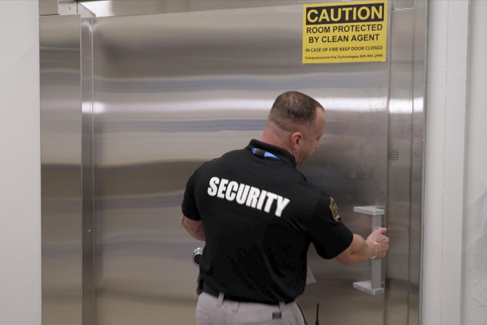 A security guard opens a steel door leading into a vault containing hundreds of collectibles at Collectors Vault, a new company that is making it easier for collectors to store and trade memorabilia, on Oct. 21, 2022, in Delaware. The door is nearly two feet thick and is meant to protect the valuables from harm and thieves. (AP Photo/Davidde Corran)