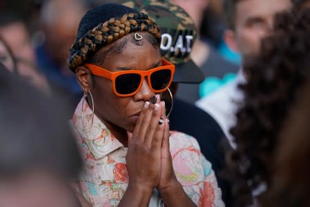 A woman prays during a vigil at the scene of a mass shooting in Dayton