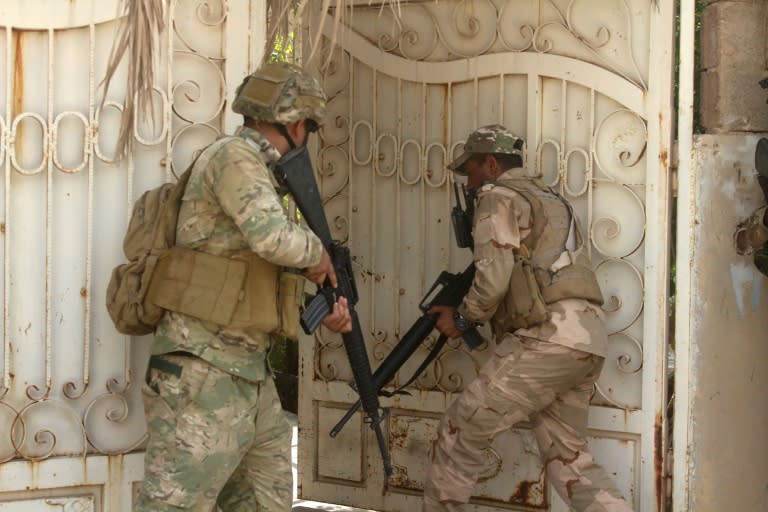 Iraqi troops storm a building in the town of Anna during the first phase of their drive up the Euphrates valley against the Islamic State group on September 22, 2017