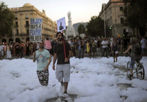 People walk at the end of a demonstration organized by unions in Barcelona. The protest was one of over 80 demonstrations called by unions across the county against civil servant pay cuts and tax hikes which drew tens of thousands of people, including police and firefighters wearing their helmets